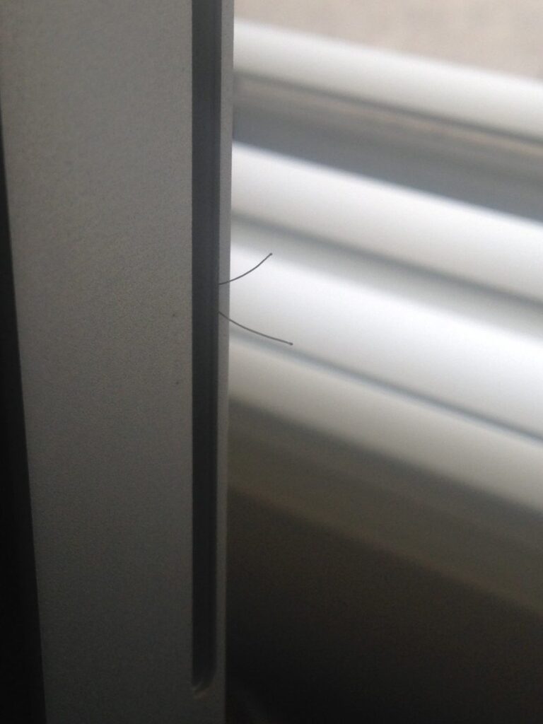 Two hairs protruding from the side disc slot of a 2011 iMac
